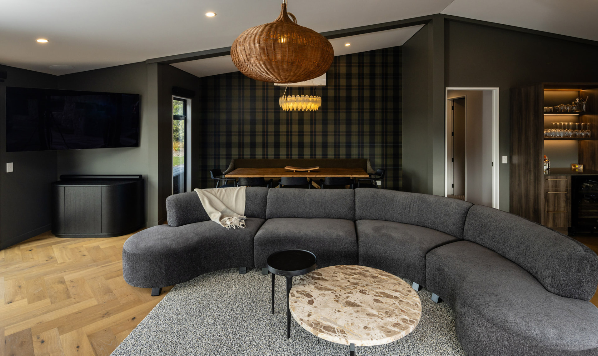 Living and dining area with curved sofa at Whakahā