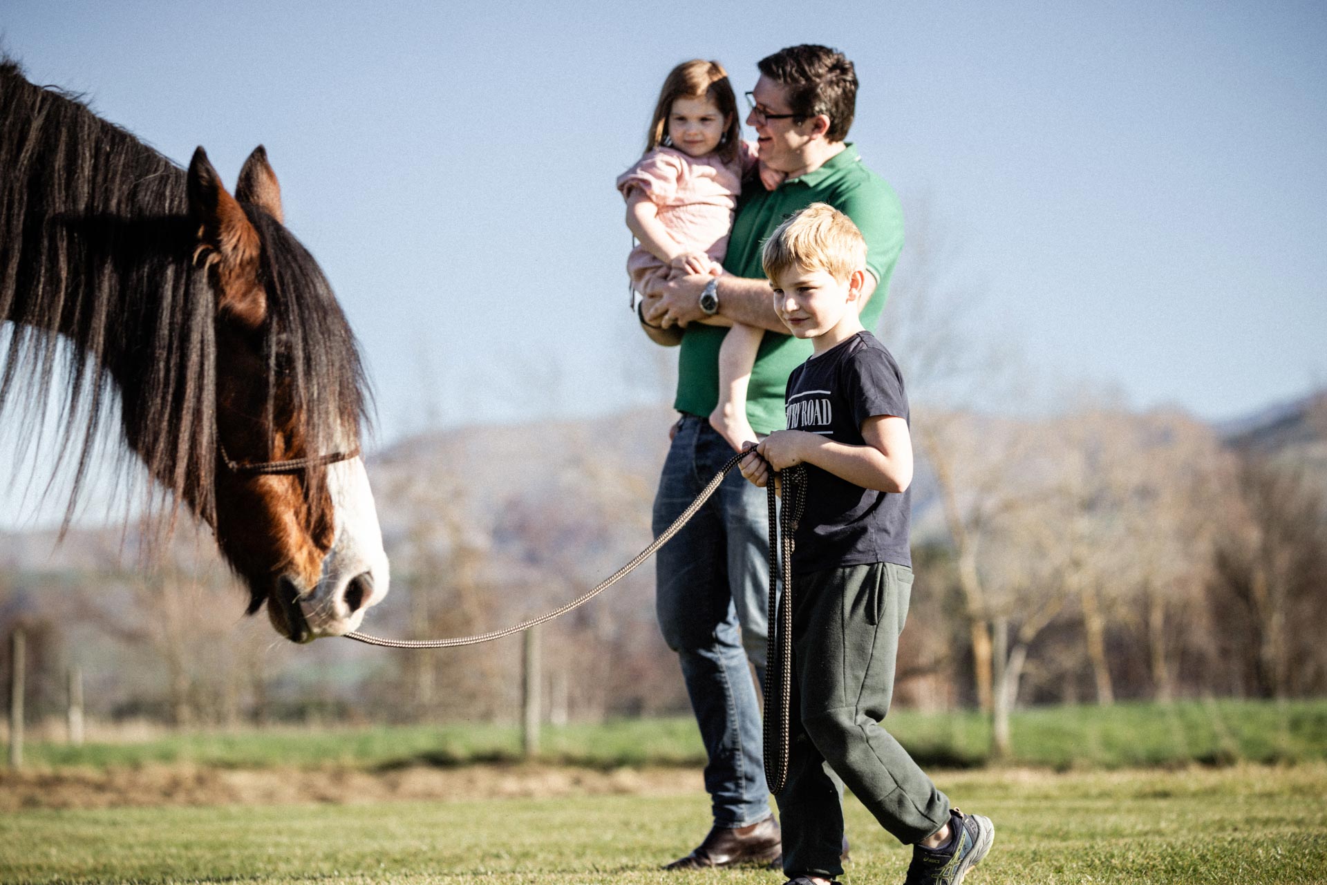 Father, son and daughter meeting a horse in the paddocks at Whakahā