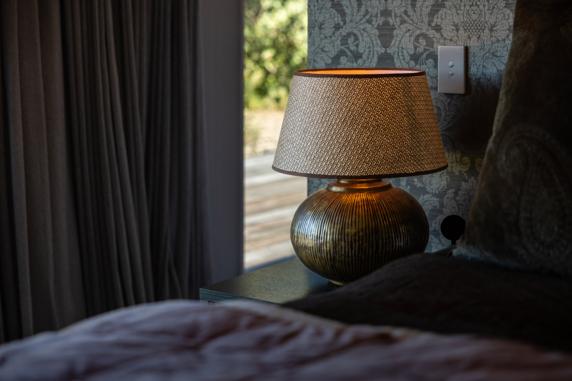Bedside lamp detail in the primary suite at Whakahā
