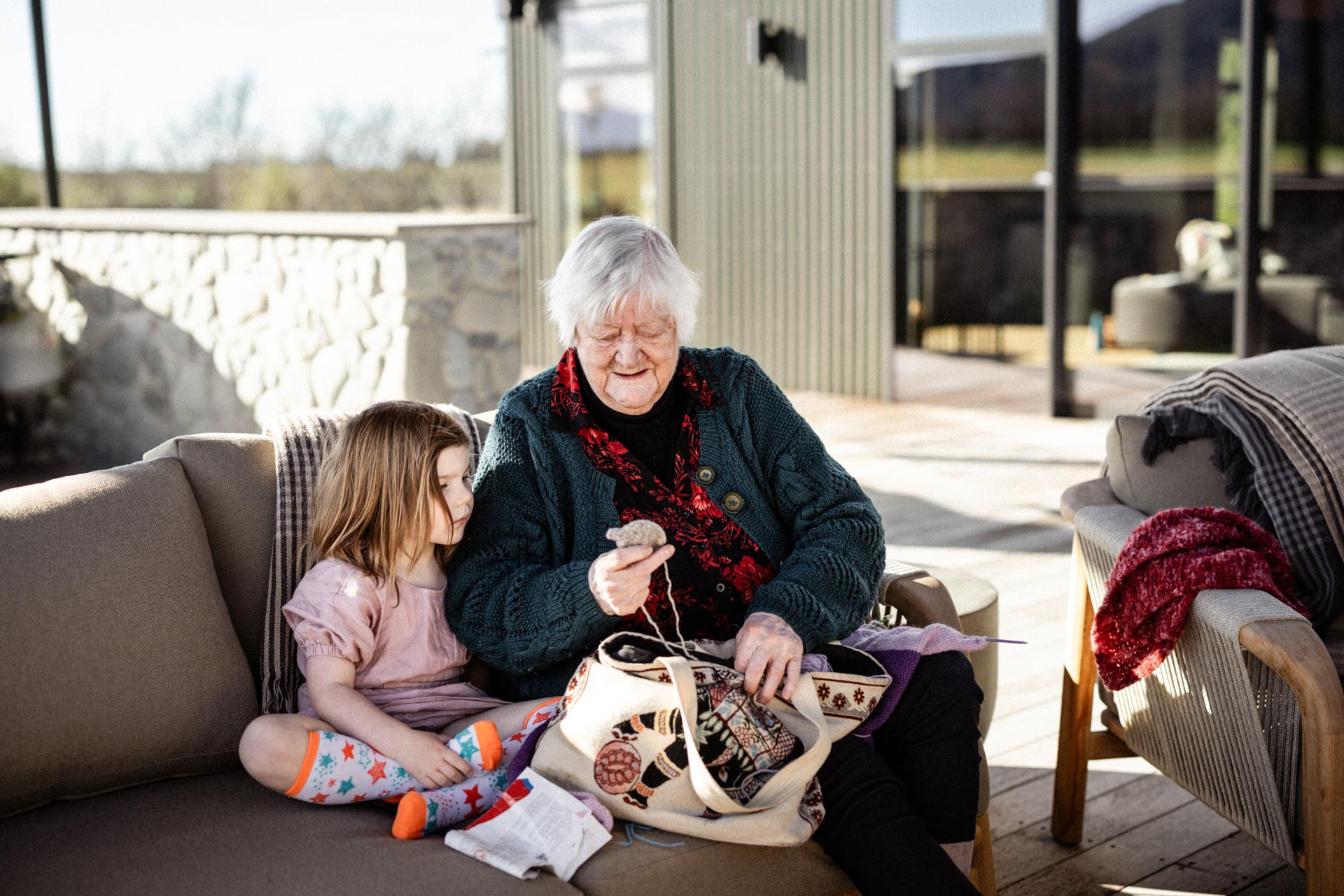 Grandmother knitting in the living room at Whakahā